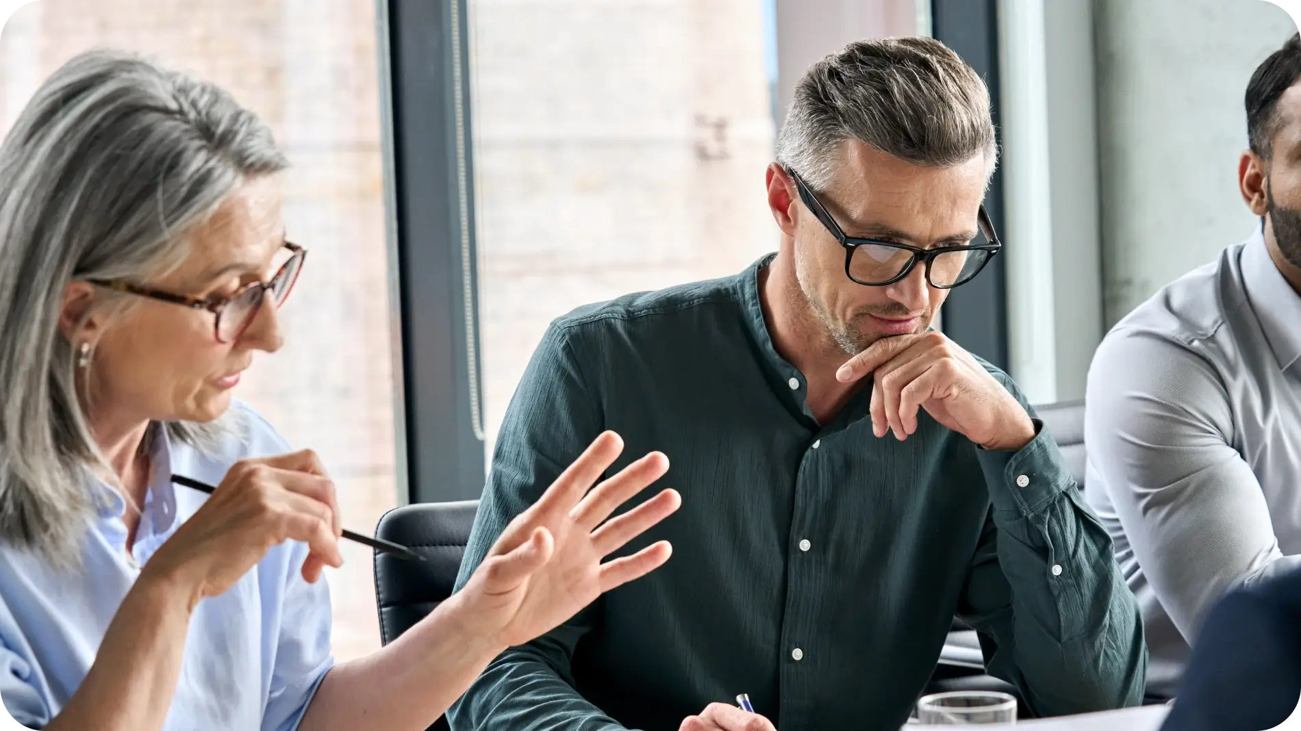 Business woman and man discussing in front of laptop.