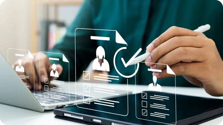 A person working on a laptop and tablet, using a stylus to interact with a digital interface. Floating holographic icons of user profiles, checklists, and a verification checkmark represent digital data management and approval processes.