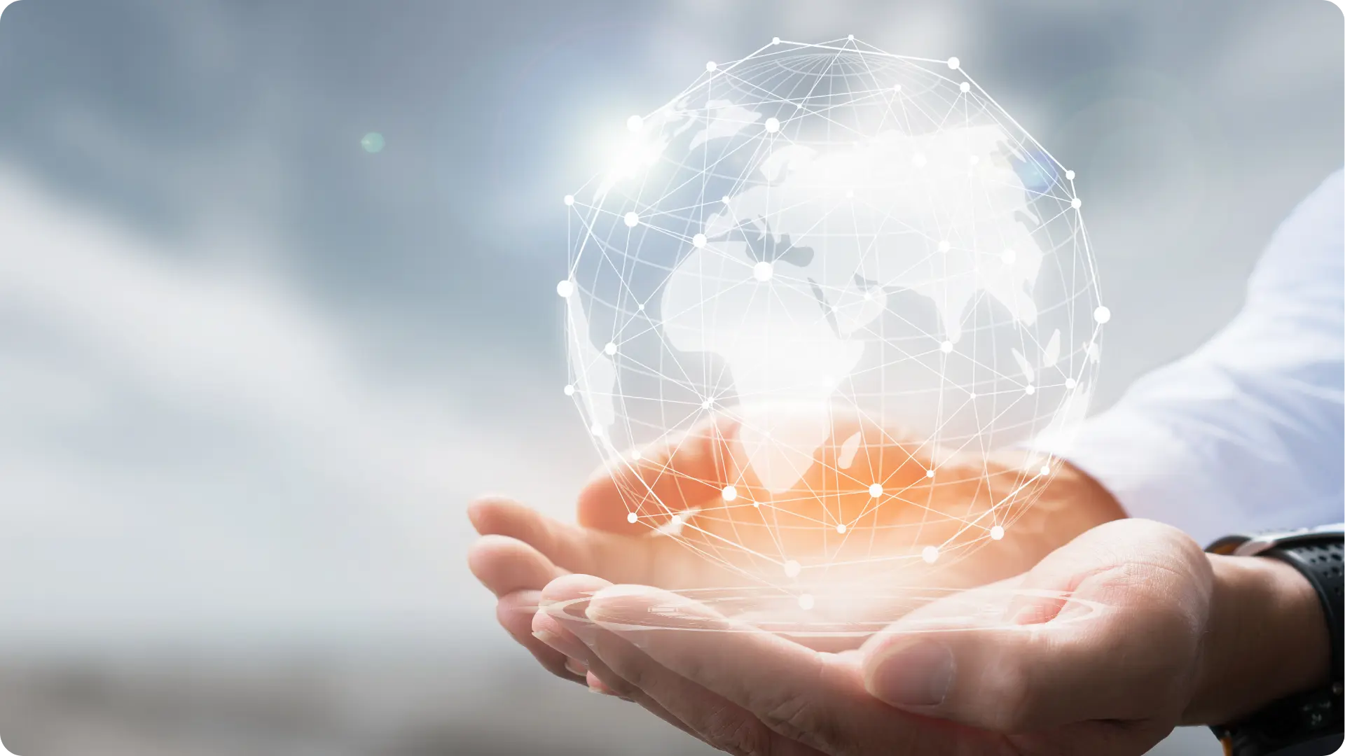 A person holding a transparent tablet with a glowing digital globe above it.